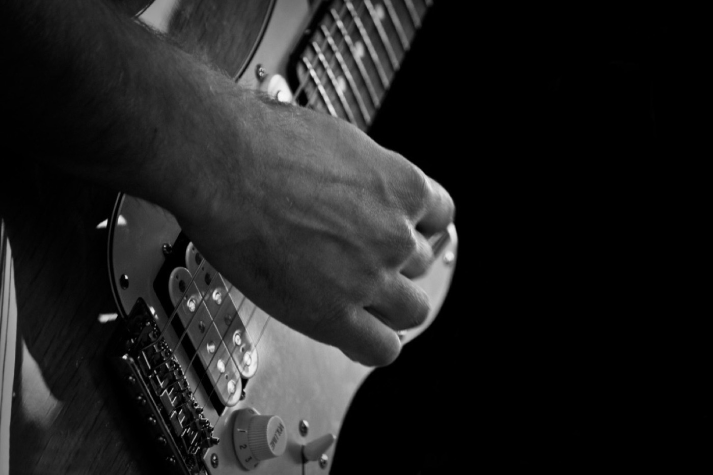 Hand spielt E-Gitarre, schwarz-weiß